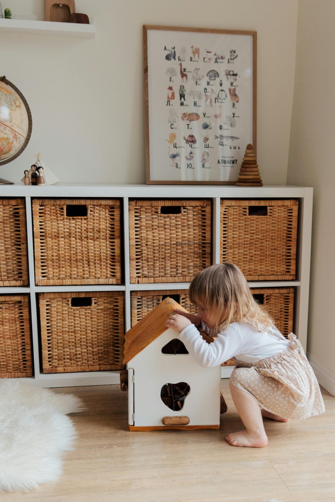 Little Girl happily playing with a doll house