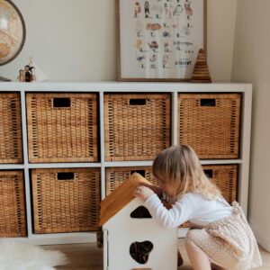 Little Girl happily playing with a doll house