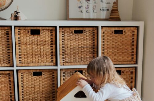 Little Girl happily playing with a doll house