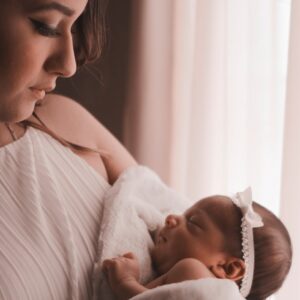 selective focus photography of woman carrying her cute baby